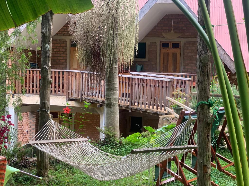 uma rede em frente a uma casa com um alpendre em David Crater Homestay em Lushoto