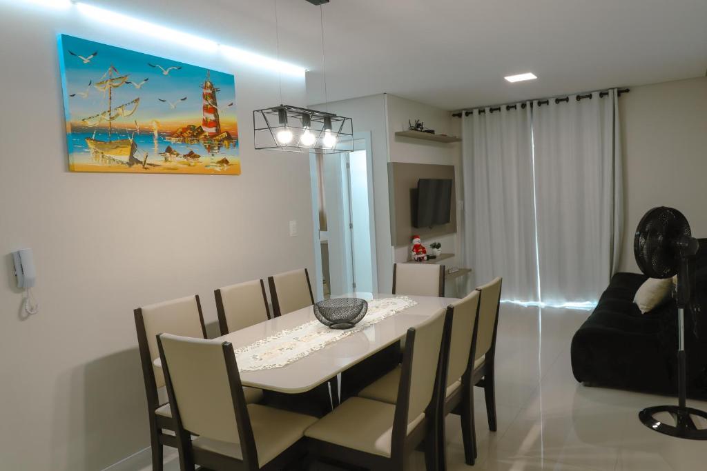 a dining room with a white table and chairs at Apartamento Familiar III Próximo Beto Carrero e Praia in Penha