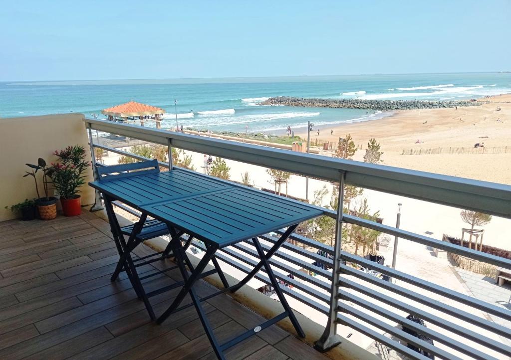 un banc bleu assis sur un balcon donnant sur la plage dans l'établissement T2 vue mer, à Anglet
