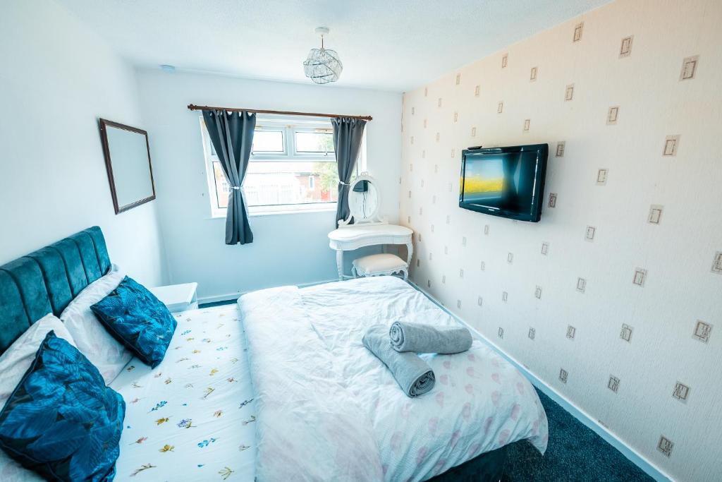 ein Schlafzimmer mit einem Bett und einem Fernseher an der Wand in der Unterkunft Manchester Retreat for Families Workers Contractors and Event Goers in Manchester