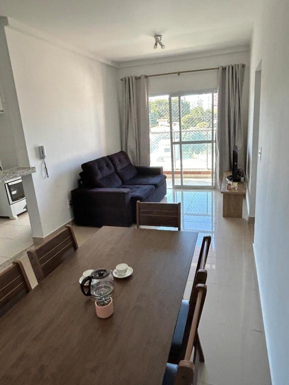 a living room with a table and a couch at Apê Master 3 dorm espaçoso in São Carlos