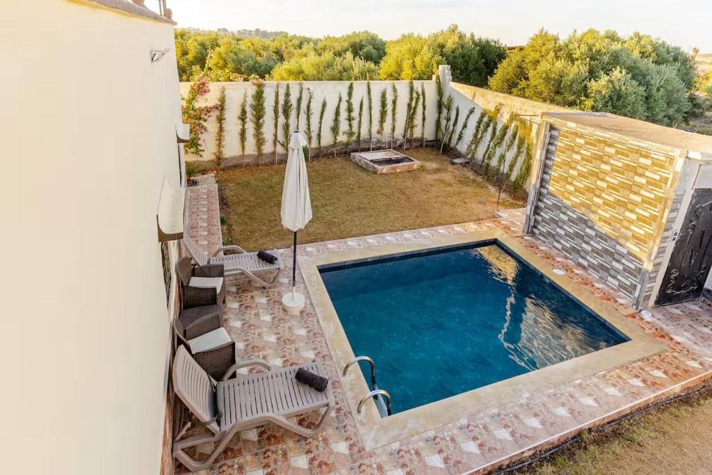 un cortile con piscina e recinzione di Amazing Home in Agafay With Pool & garden a Marrakech