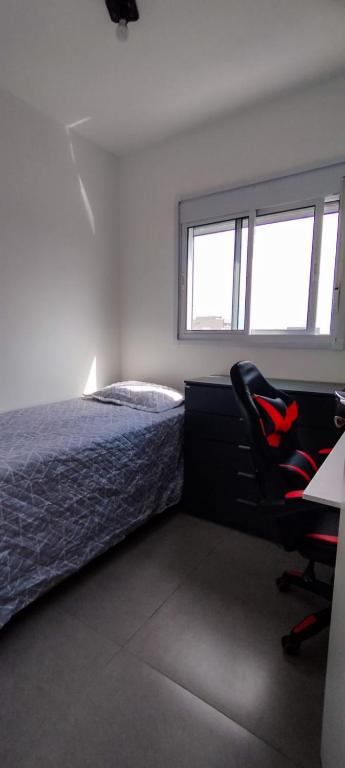 a bedroom with a bed and a desk and a chair at Quarto privativo Morumbi in São Paulo