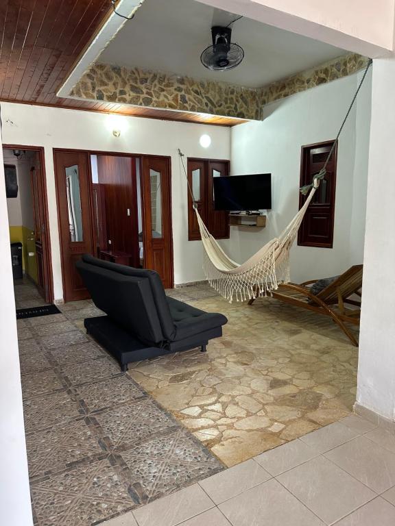 a hammock in a living room with a tv at Glamar Casa in Arboletes