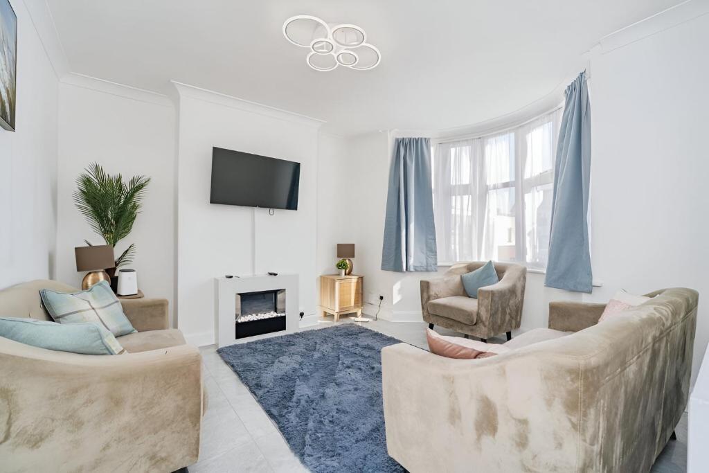Hotel EEJs Stylish 3 Bedroom House - Greenwich, a living room with two chairs and a tv at EEJs Stylish 3 Bedroom House - Greenwich in London