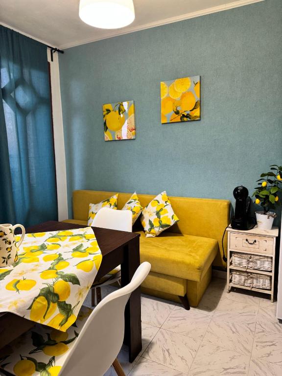 a living room with a table and a yellow couch at Villa Nikoleta in Sveti Vlas