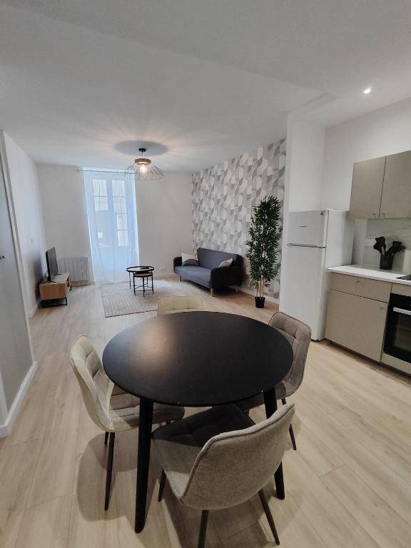 a kitchen and a living room with a table and chairs at Appartement Confort Cholet in Cholet