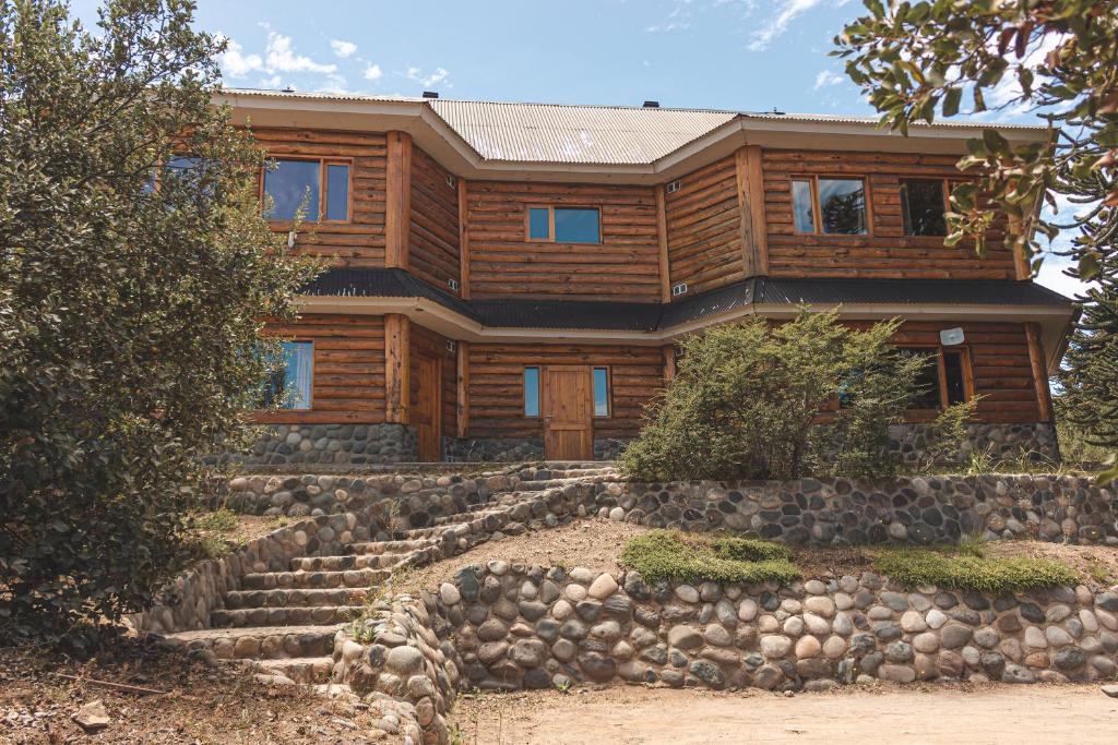 ein Holzhaus mit einer Treppe davor in der Unterkunft Apart al Lago in Villa Pehuenia