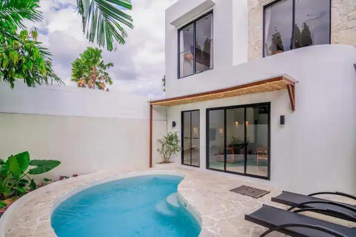 a swimming pool in front of a house at Villa Casa Sea Salt in Denpasar
