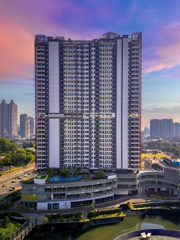a large tall building with a river in front of it at Citadines Antasari Jakarta in Jakarta
