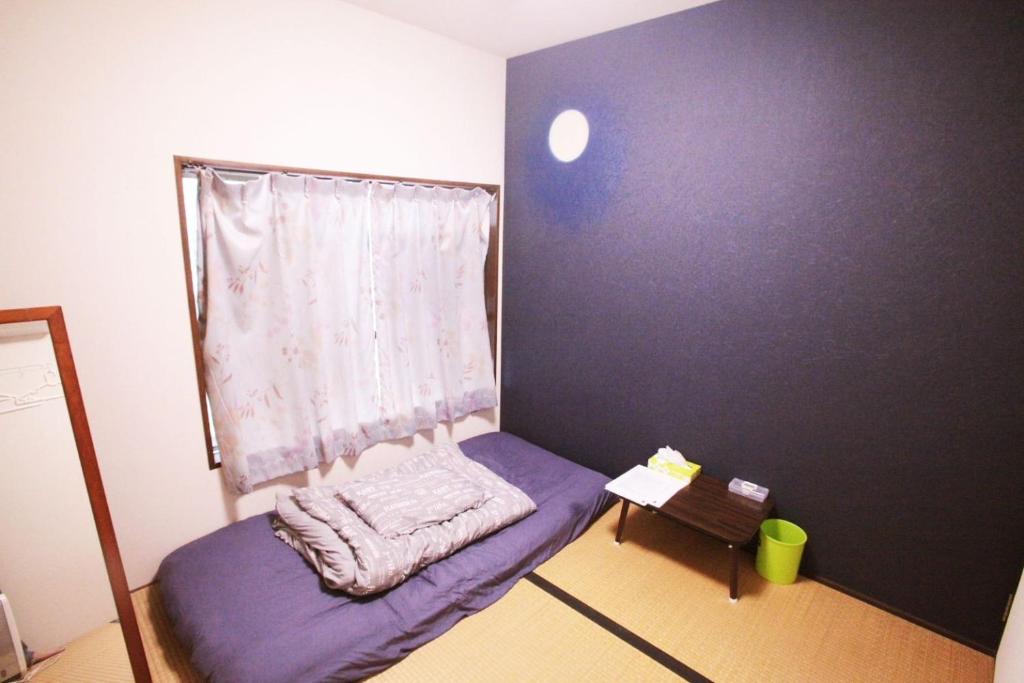 a small bedroom with a purple bed and a window at 2F - Vacation STAY 41690v in Okinawa City