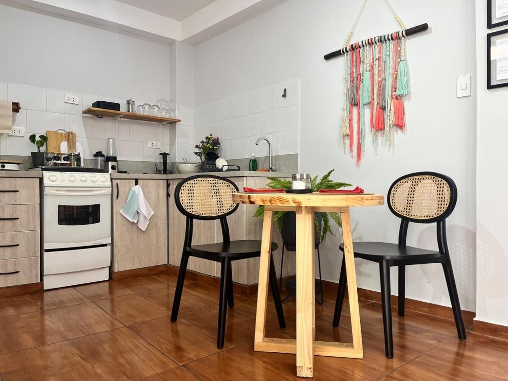 Una cocina con una mesa de madera y dos sillas. en Cozy stay with private garden in Taray Pisac, en Taray