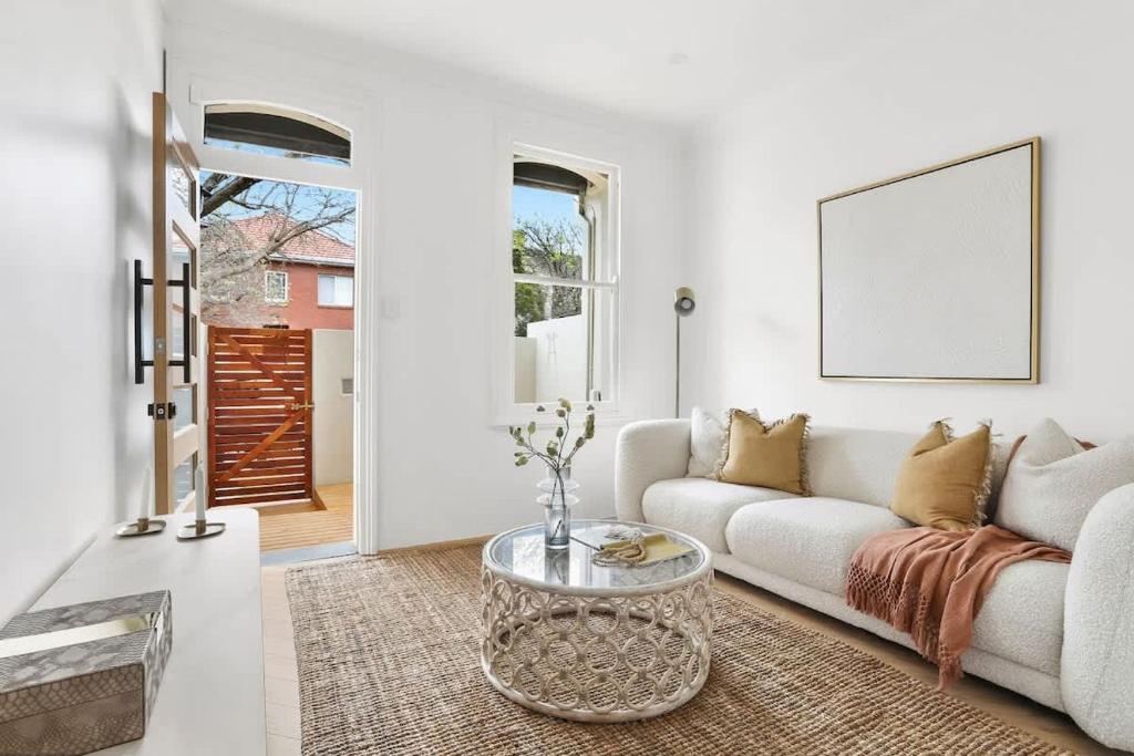 a living room with a white couch and a table at 3 Bedroom Split level terrace at Bondi Junction in Sydney