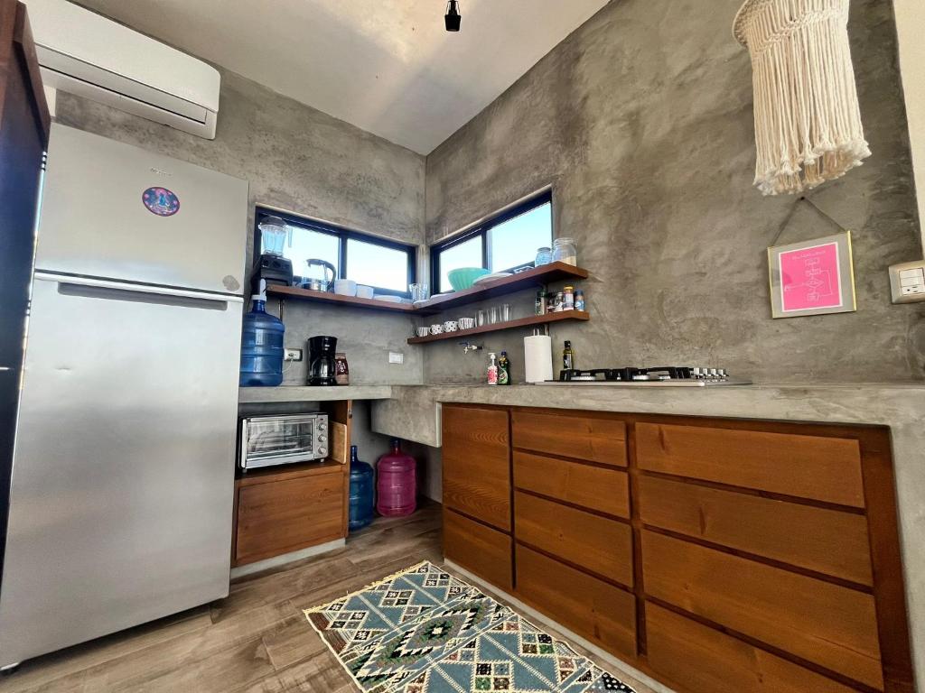 a kitchen with a stainless steel refrigerator and wooden cabinets at Casa Mantra Ocean View & Private Terrace in La Ventana