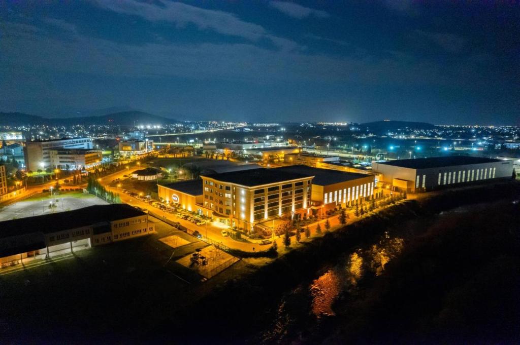 una città illuminata di notte con edifici e luci di voco - Podgorica by IHG a Podgorica