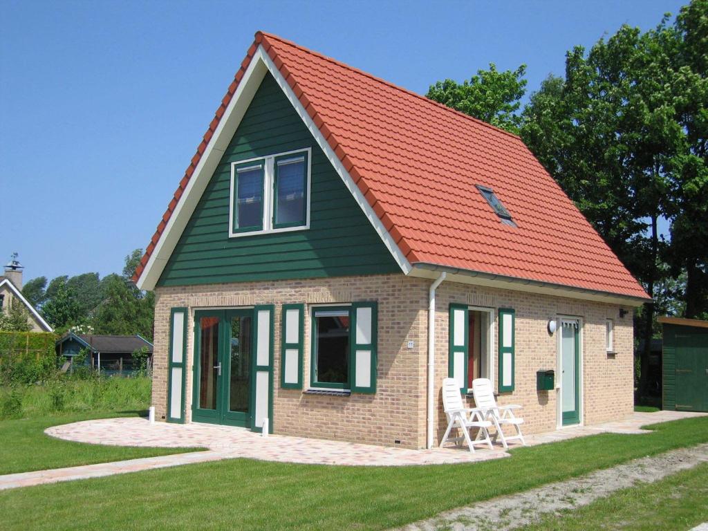 uma pequena casa com um telhado laranja em Holiday home near Grevelingen Lake em Zonnemaire