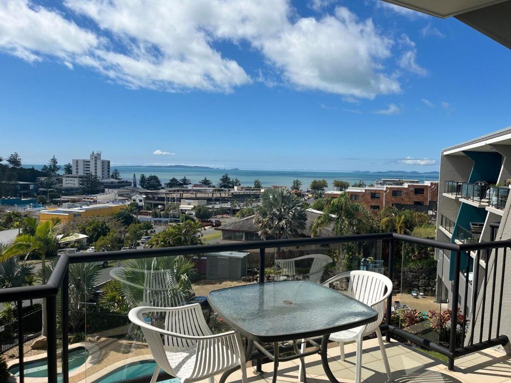 un patio con tavolo e sedie su un balcone di Panoramic Ocean View CBD Appartment a Yeppoon