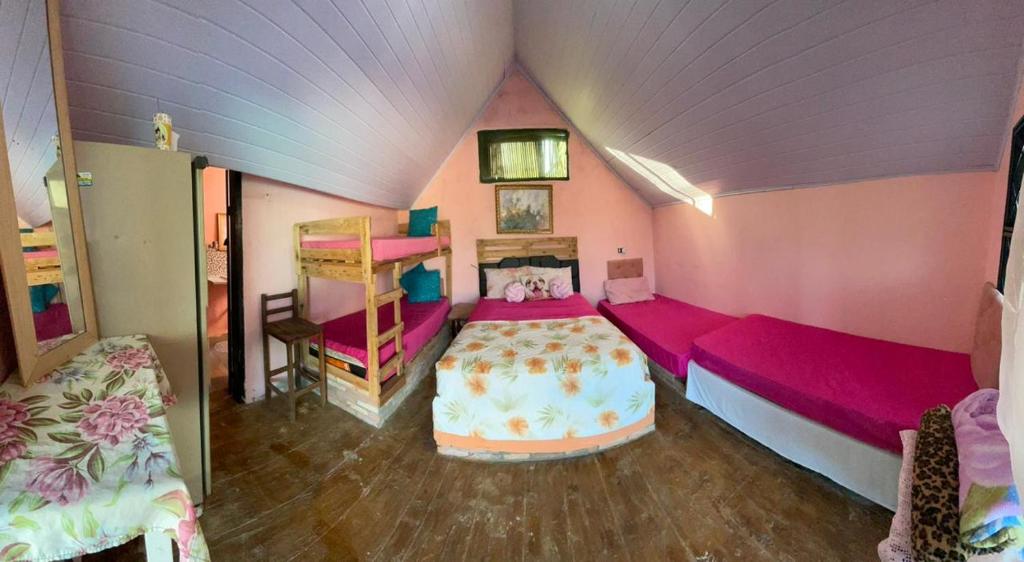 1 dormitorio con paredes rosas y 1 cama en una habitación en Recanto Pousada Elshaday sede, en Osvaldo Cruz