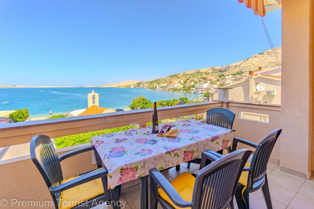 a table and chairs on a balcony with a view of the ocean at Zutenica Seaside Residence in Metajna