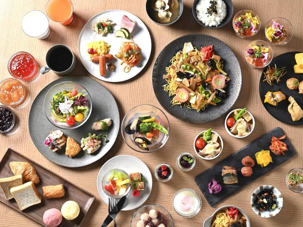 una mesa con platos de comida y tazones de comida en GRIDS PREMIUM HOTEL OTARU, en Otaru