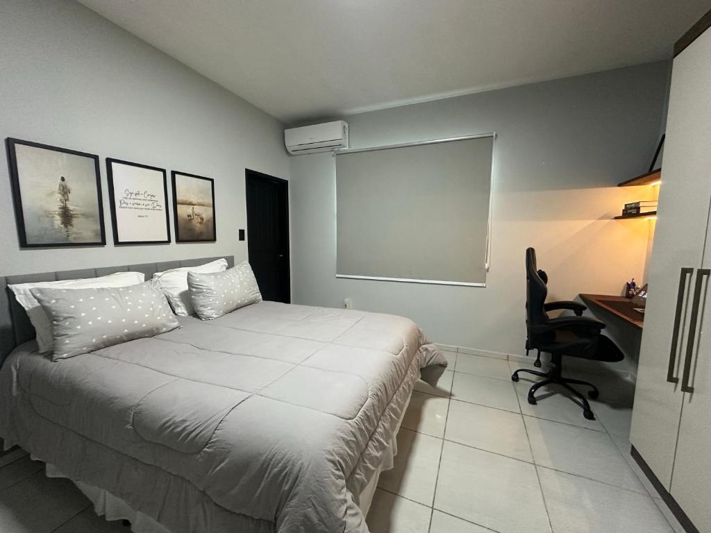 um quarto com uma cama, uma escrivaninha e uma cadeira em Casa com garagem privativa, Perto do Centro em Joinville