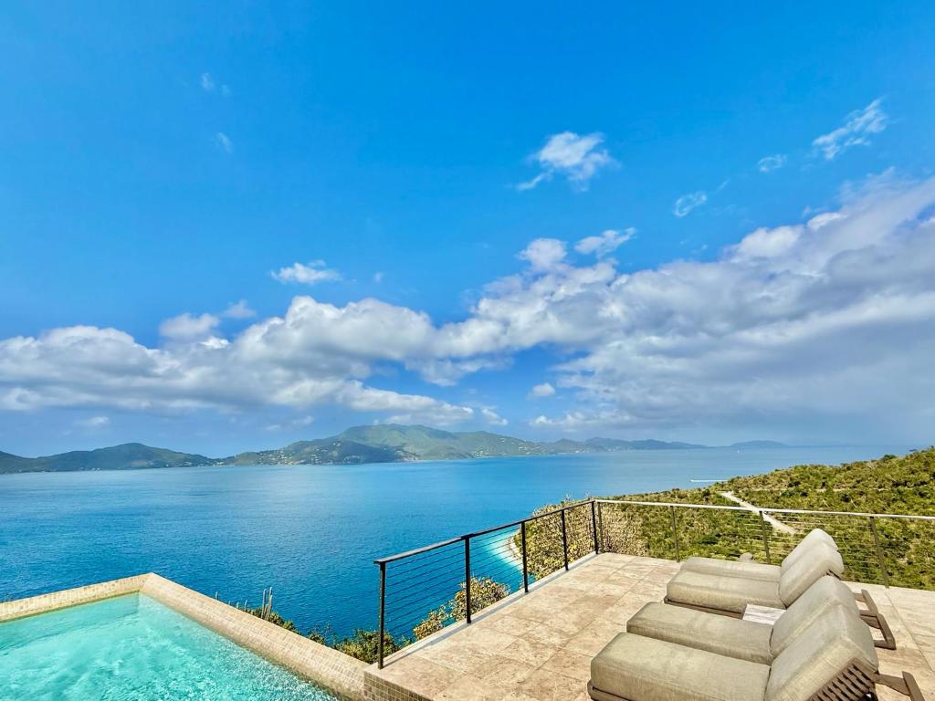 a swimming pool with a view of the water at Window to the Sea - Phenomenal Pool and Hot Tub Villa in East End