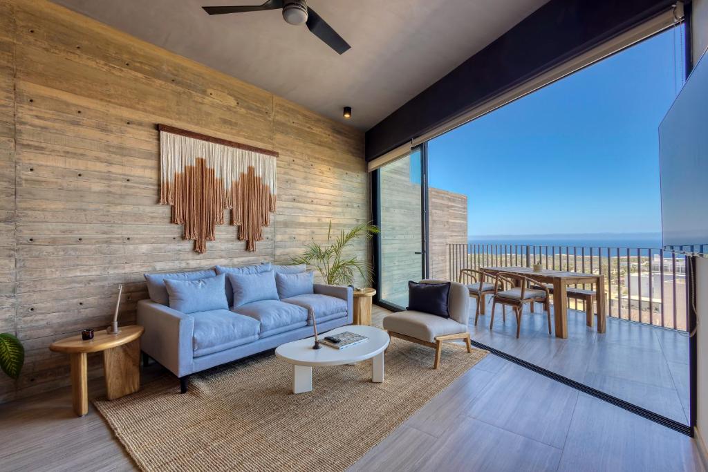 a living room with a blue couch and a table at OR Cabo Boutique Residences by Lumina in Cabo San Lucas