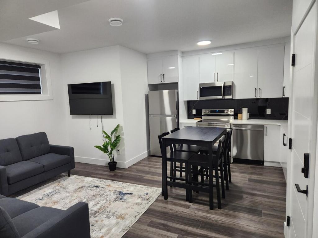 een keuken en woonkamer met een tafel en stoelen bij Home Away from Home 2 bedrooms in Edmonton