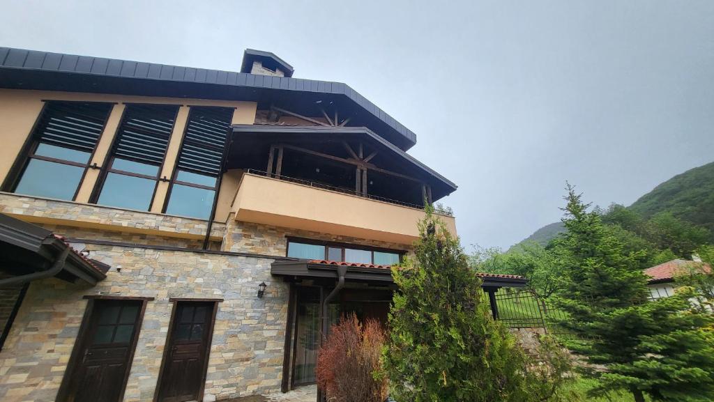 a large building with windows and mountains in the background at Къща за гости Seltse Villa in Seltse