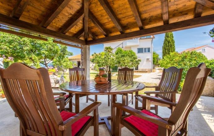 a wooden table and chairs on a patio at Garten House in Kornić