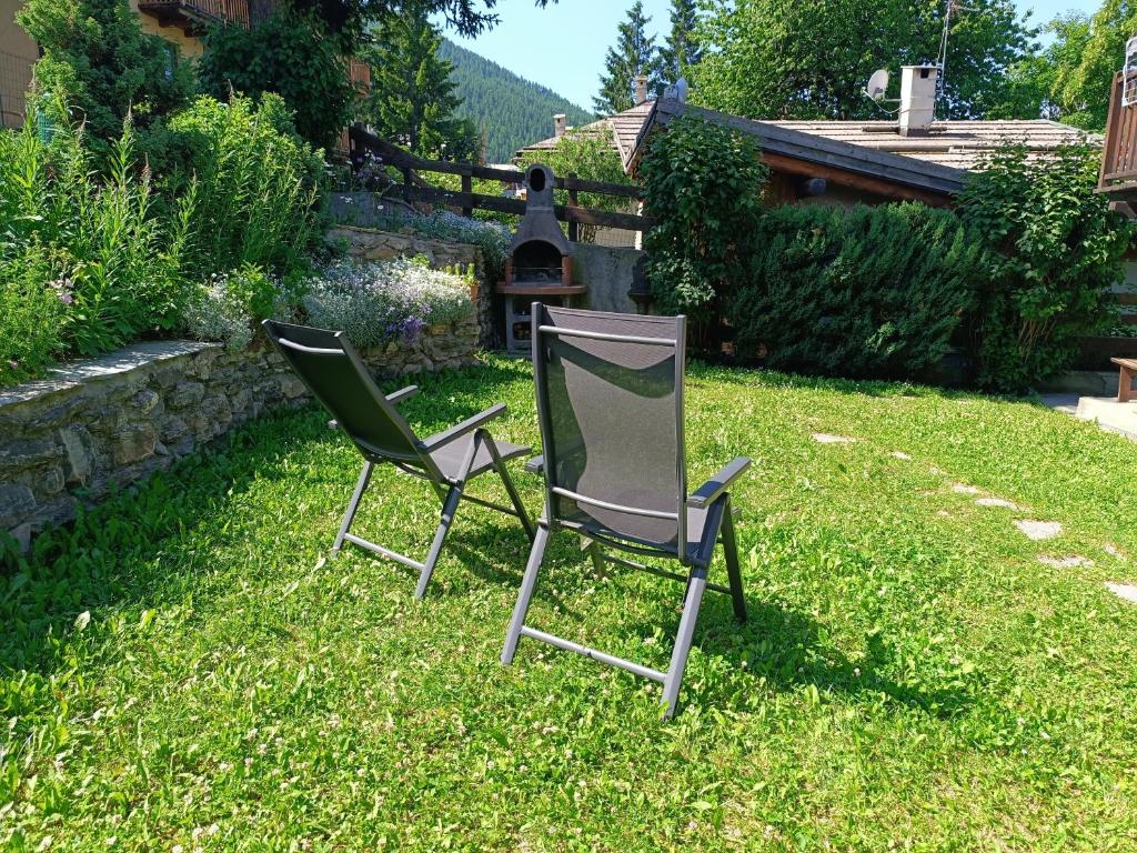 two chairs sitting in the grass in a yard at Sauze d'Oulx ciabot la garitüla with garden - wifi- close to the chairlift in Sauze dʼOulx