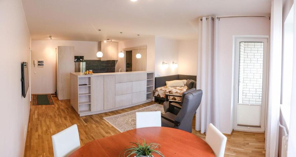 eine Küche und ein Wohnzimmer mit einem Tisch und Stühlen in der Unterkunft Metsa 49 Apartment in Haapsalu
