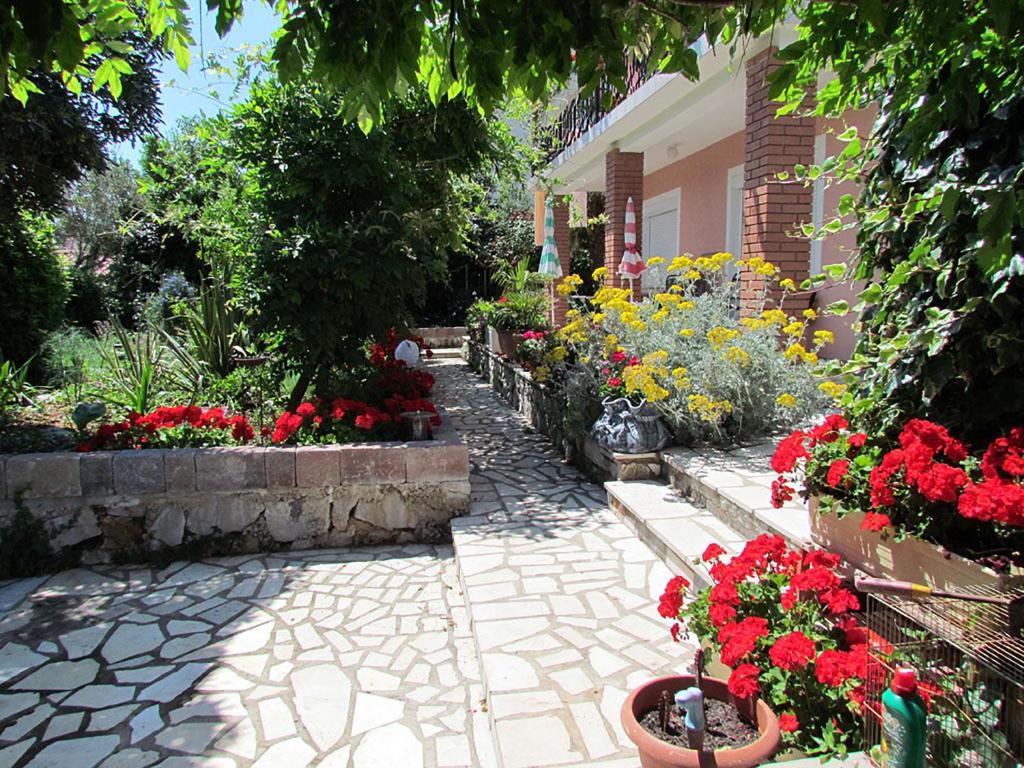 un jardín con flores en macetas y un edificio en Apartments Bura & Jugo, Cres, without stress, en Cres