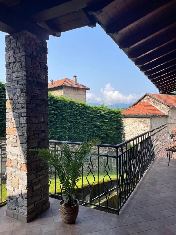 un balcon avec une clôture et une plante en pot dans l'établissement Lejlighed i Bassola med privat parkering, à Armeno