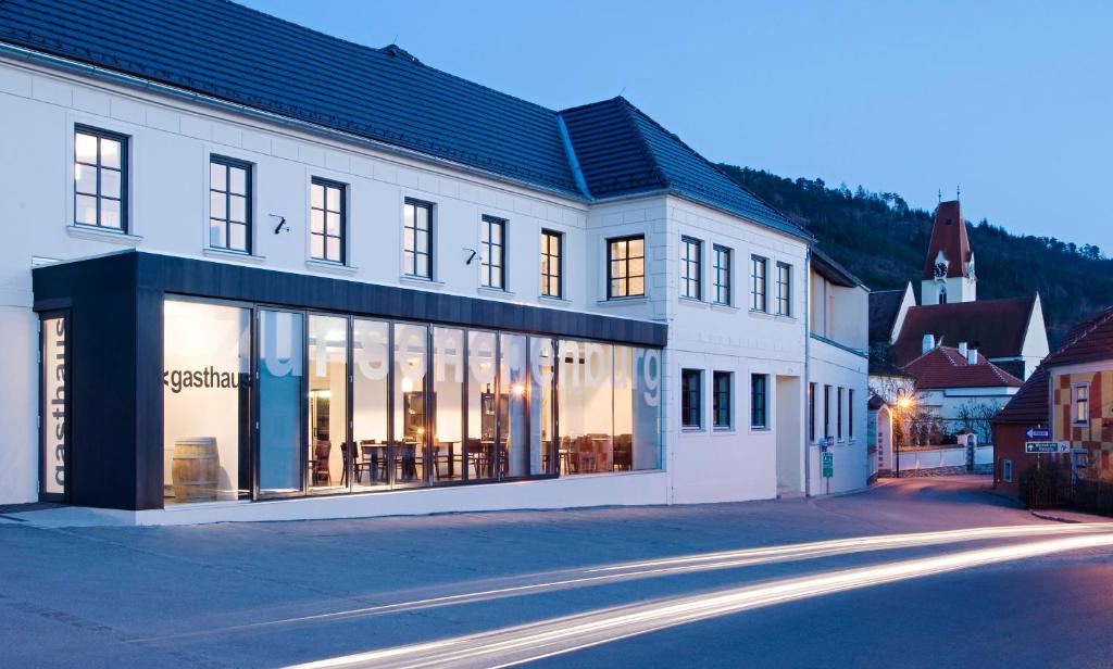 ein großes weißes Gebäude mit Fenstern auf einer Straße in der Unterkunft Hotel Zur Schonenburg in Schönberg am Kamp