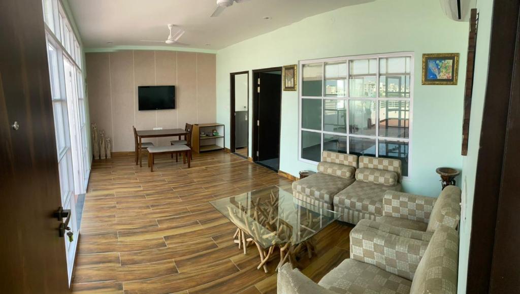 una sala de estar con un sofá y una mesa en SENTOSA penthouse, en Jaipur