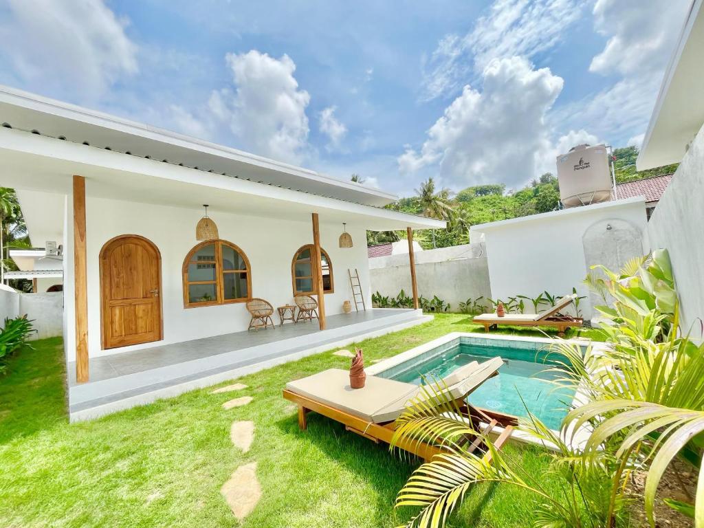 a backyard with a pool and a house at VILLA LULU 1- 2 bedrooms villa - private pool in Kuta Lombok