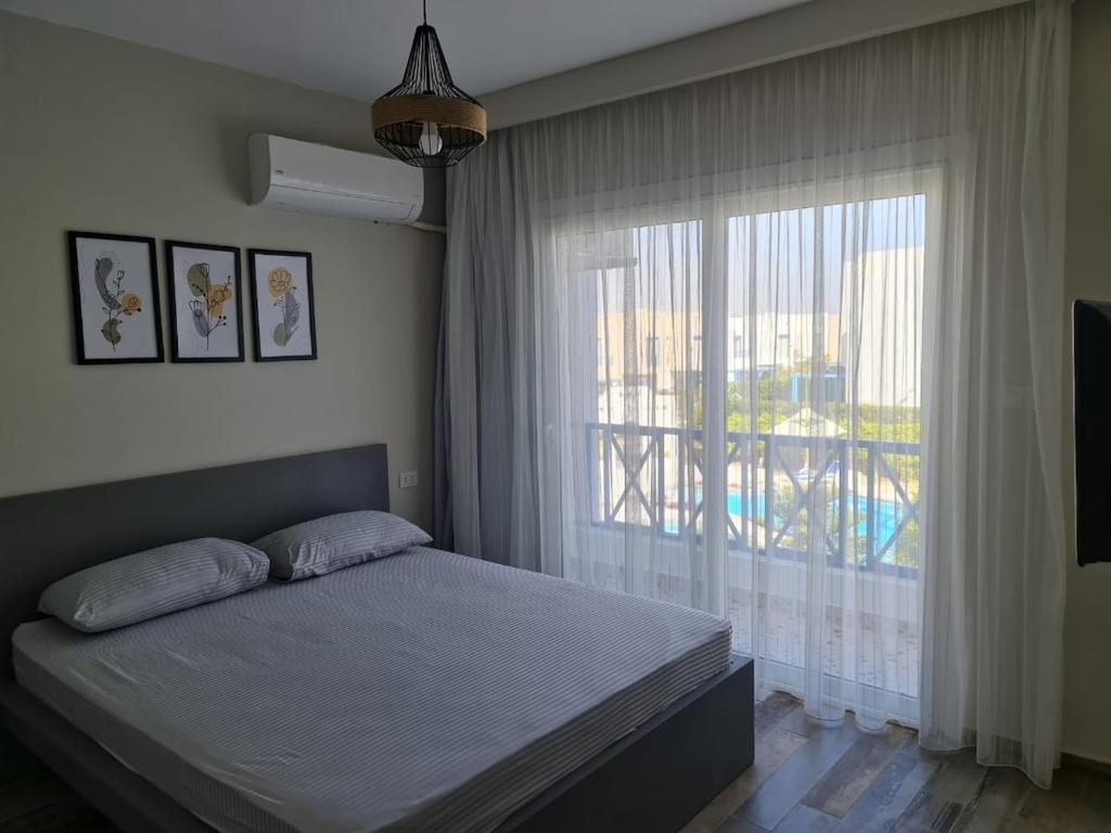 une chambre avec un lit et une grande fenêtre dans l'établissement Charming Twin House In Paros - Mountain View Ras ElHikma - North Coast Egypt, à Ras Elhekma