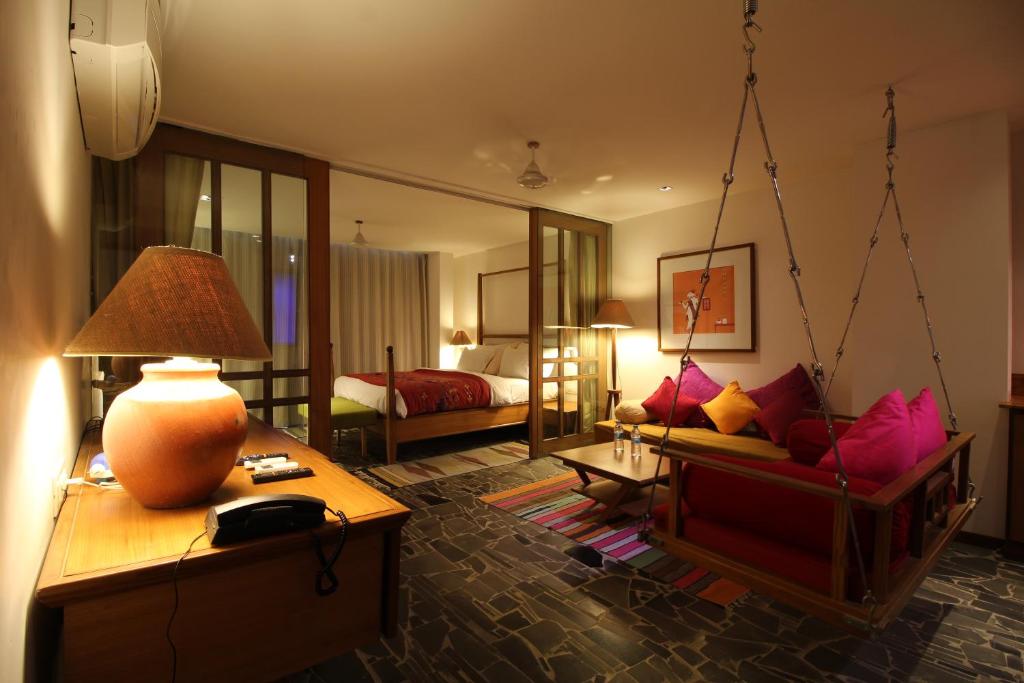 un soggiorno con letto a dondolo e una camera da letto di The Sky Imperial Aarivaa Luxury HomeStay a Rajkot