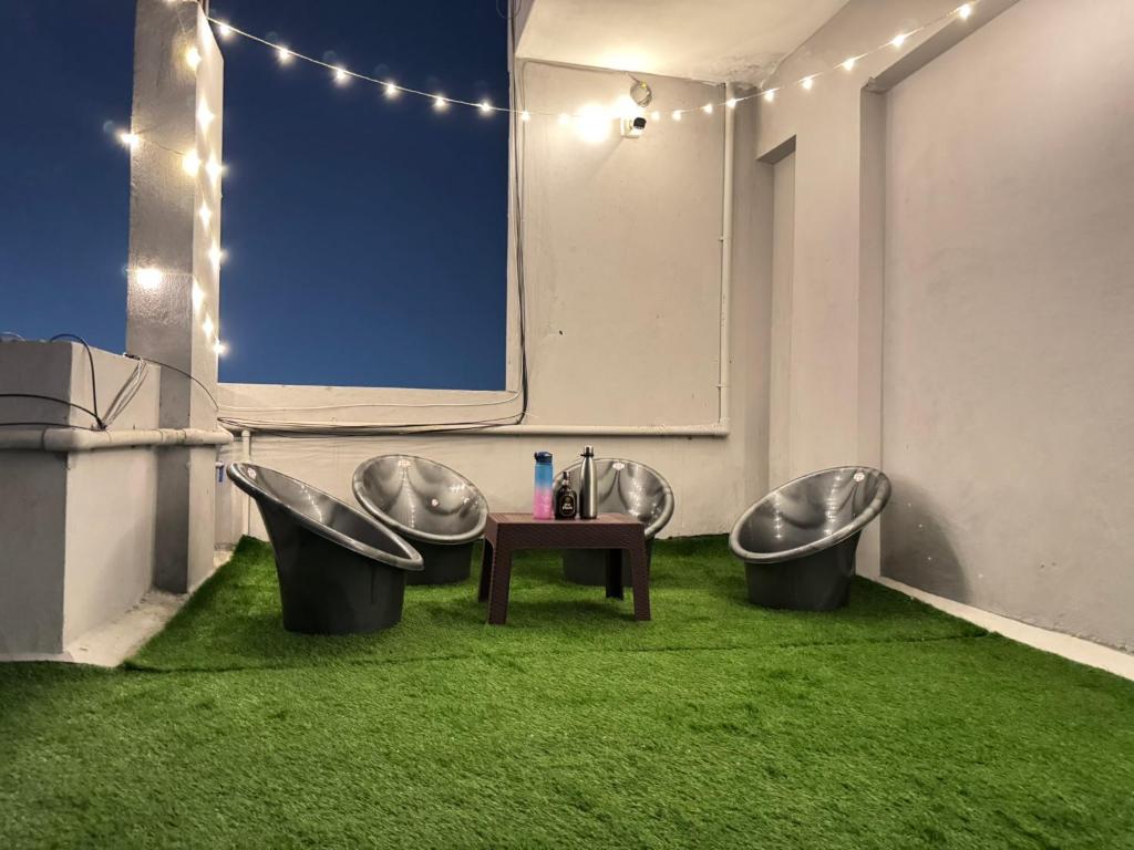 a bathroom with three sinks and a table with green grass at Penthouse Escape 1BHK Park View Flat in Kondapur in Hyderabad