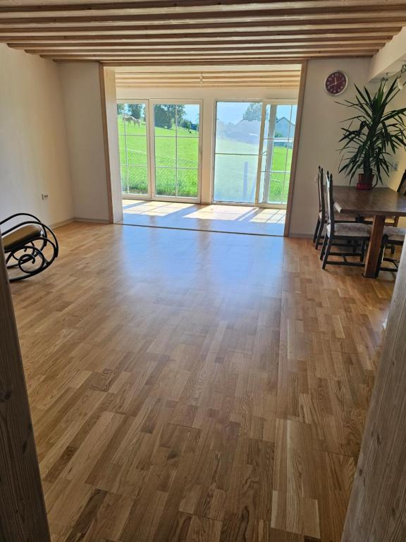 a living room with a wooden floor and windows at Bright 3-Bedroom Apartment in Hechelmannskirchen