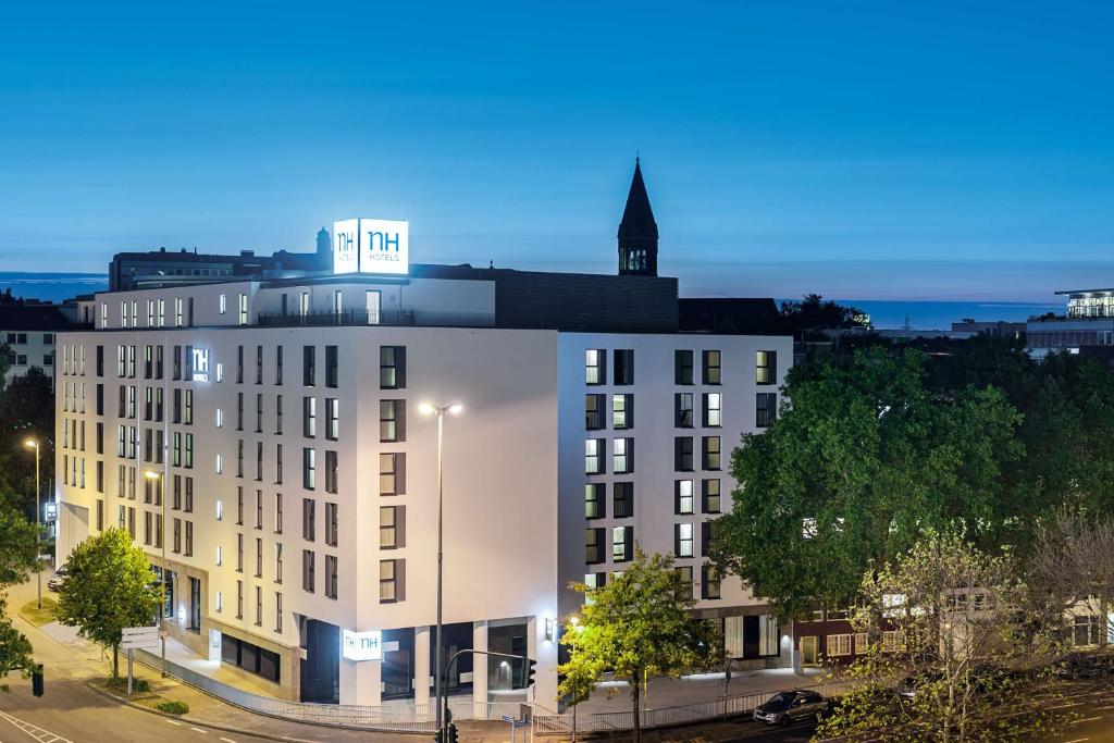 a white building with a clock tower on top of it at NH Essen in Essen