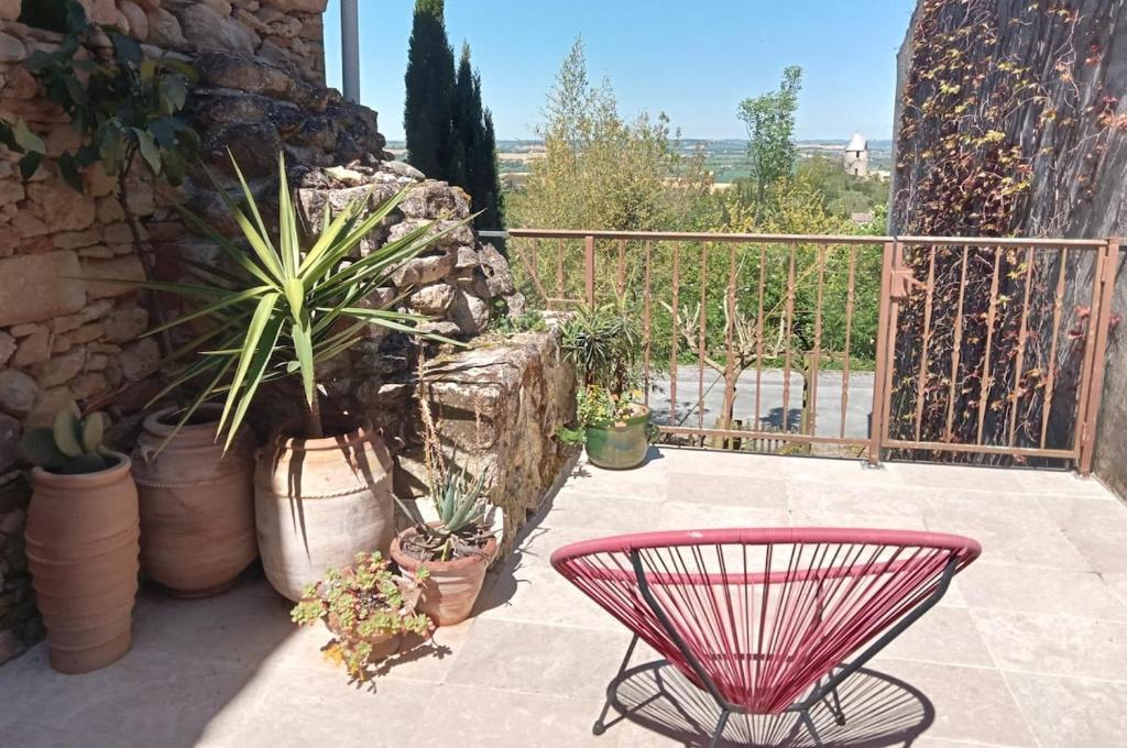 a patio with a pink table and potted plants at La Terrasse des Moulins Maison de Charme in Saint-Félix-Lauragais