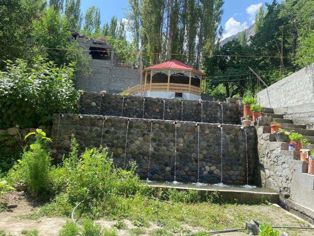 a stone retaining wall with a gazebo on top at Brookfall resort khaplu in Khaplu