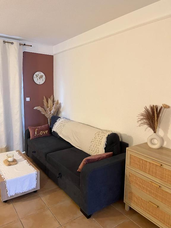 - un salon avec un canapé et un oreiller dans l'établissement Terrasse avec parking, à Uzès