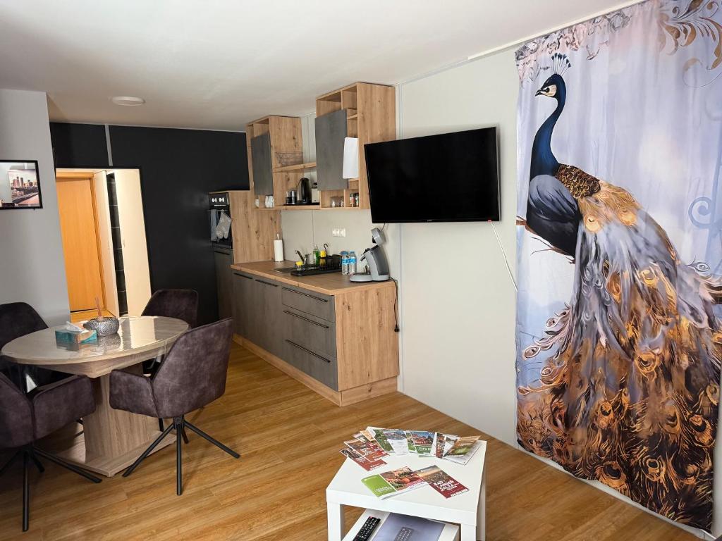a living room with a large peacock painting on the wall at Ferienwohnung Vierjahreszeiten Winter in Bad Langensalza
