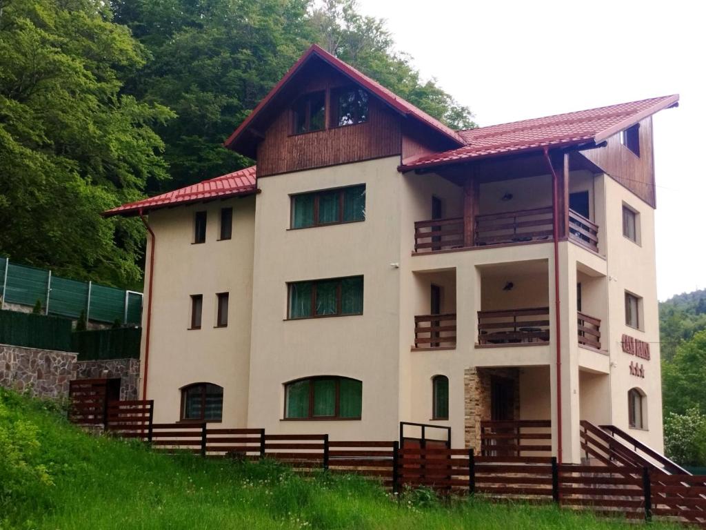 a house on top of a hill with trees at Casa Raisa in Buşteni