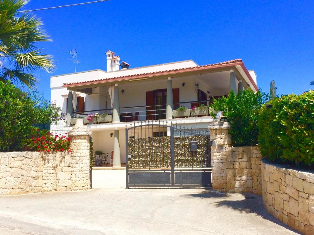 una casa blanca con una puerta y una valla en B&B All'ombra degli ulivi, en Ostuni