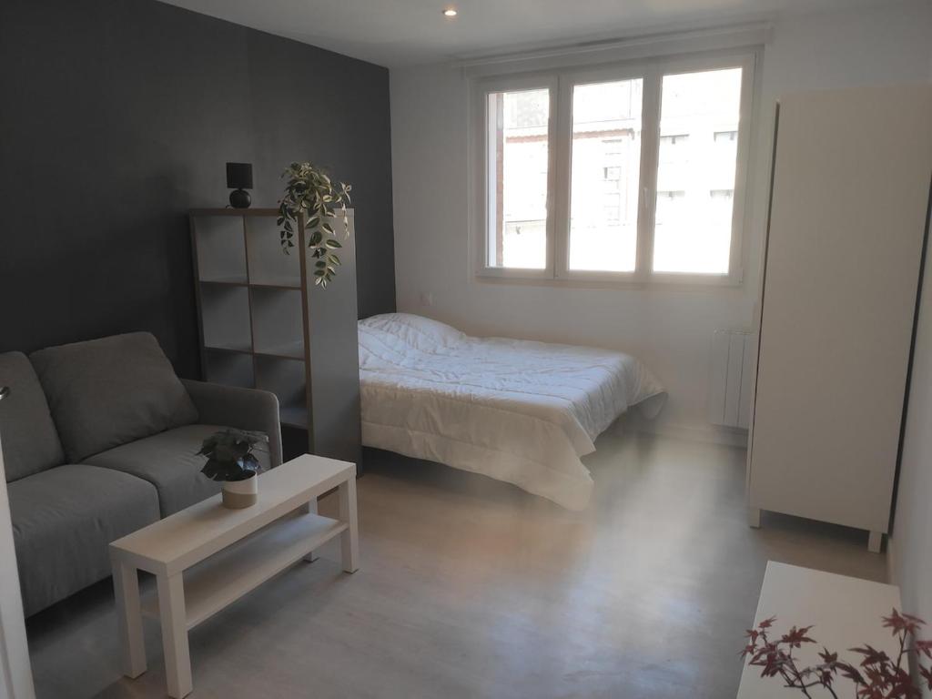 una sala de estar con una cama y un sofá en Intimissime, en Dunkerque