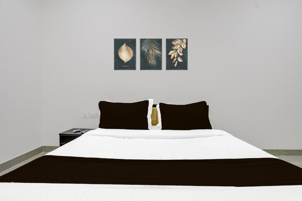 a bedroom with a white bed with black pillows at FabHotel Casa in Nagpur